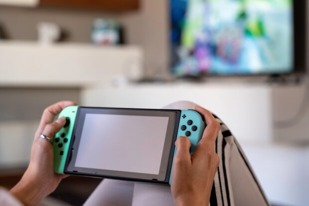 A person playing on a Nintendo switch.