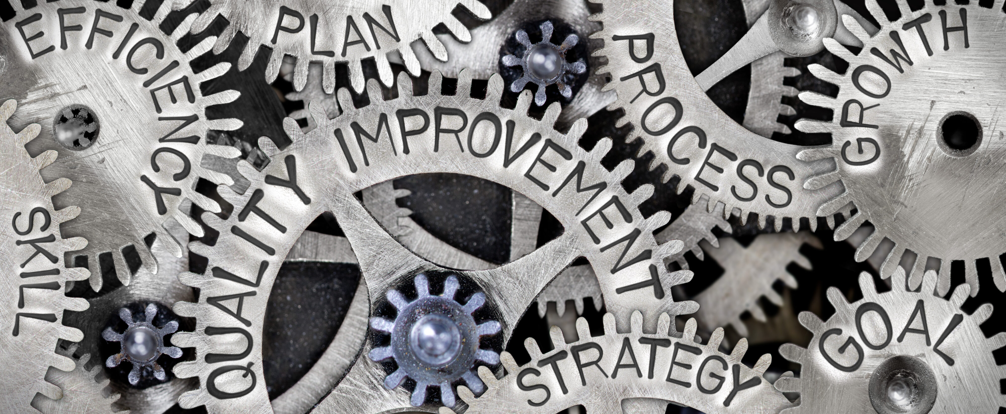 Metal cogs each with a different word such as 'improvement, 'efficiency', 'process'. and 'strategy'. Credit: Shutterstock