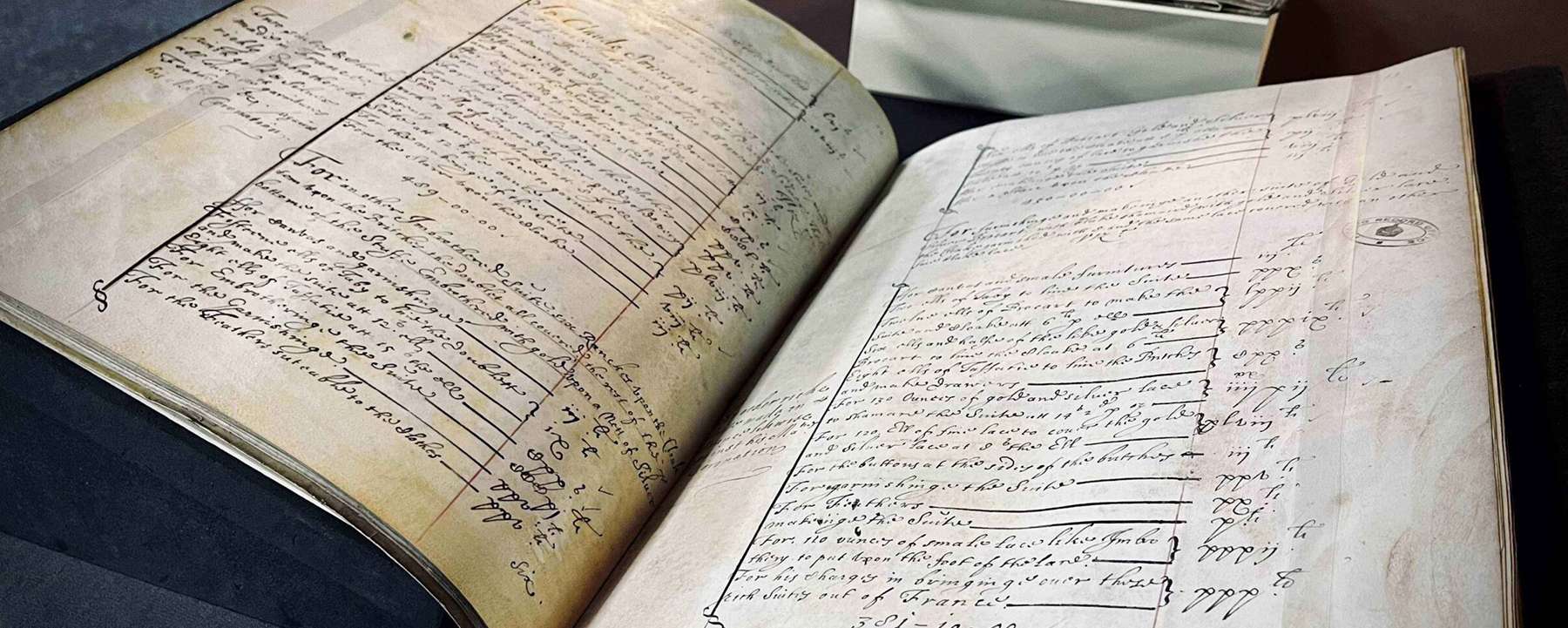 A historical volume lies open in a display case, revealing several handwritten lists.