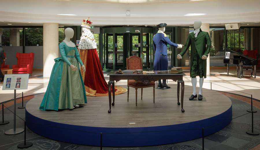 A display in The National Archives entrance. There are four mannequins wearing 18th-century clothing. They are dressed as King George, George Washington, and Eliza and Alexander Hamilton.