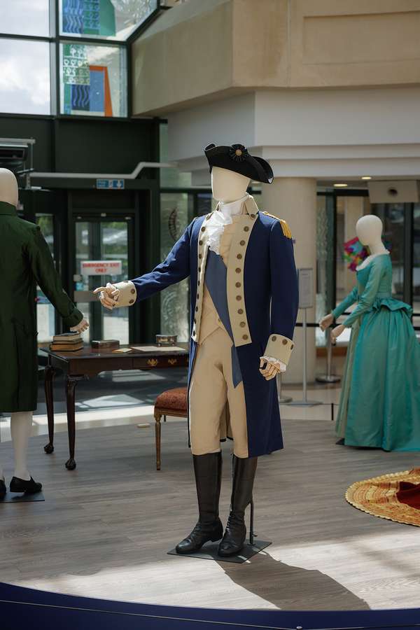 A display in The National Archives entrance. There is a mannequin dressed at George Washington. It is wearing a blue military coat and hat.