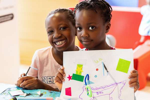 Two children showing their creations at craft club.