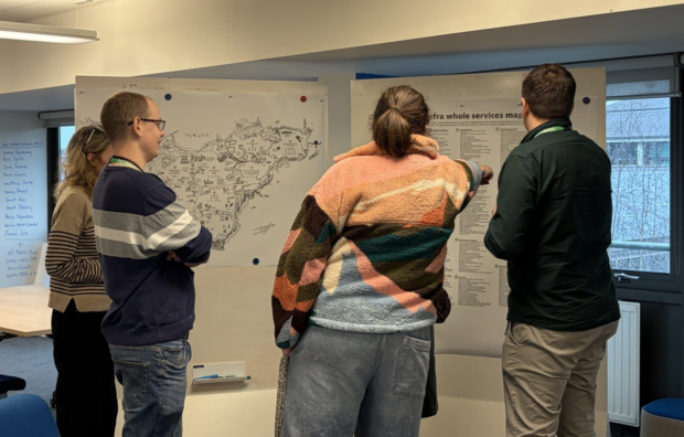 A group of people standing around a whiteboard