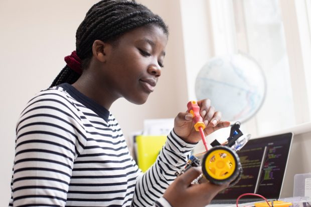 Female student building a robot.