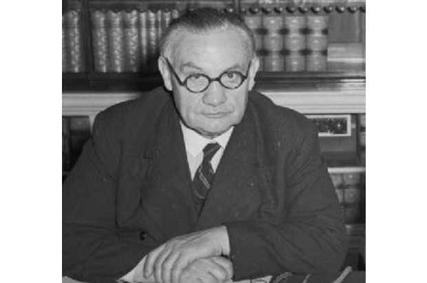 Ernest Bevin an elderly Prime Minister posing for a picture in front of a book case