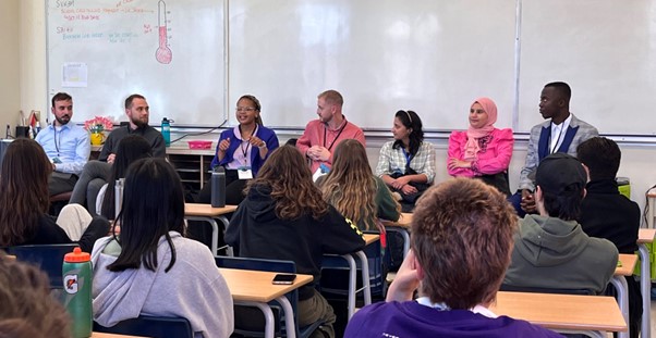 delegates talking to a room of students