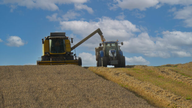 tractor and combine harvester in a field