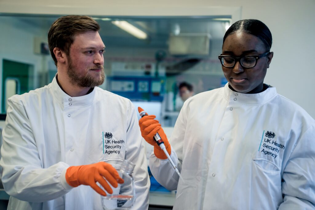 Picture of two UKHSA staff in a lab