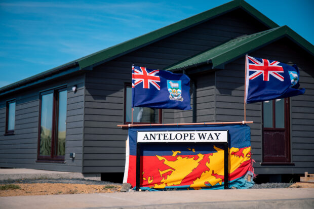 wooden building with flags and road sign that says Antelope Way