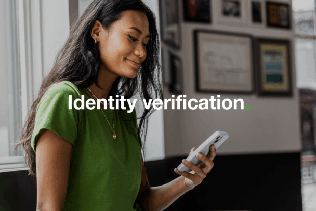 A woman is holding and looking at her mobile phone, with the words 'identity verification' over the top