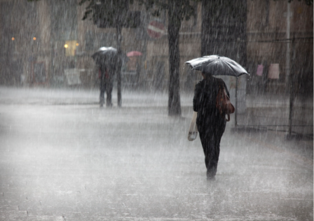 A commuter walking through flooding in London