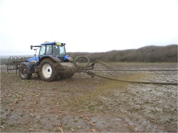 A tractor spreads slurry on a field
