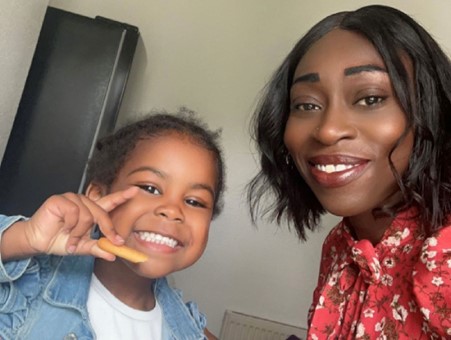 Shanayd smiling with the child she cares for as a kinship carer.