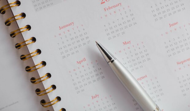 A pen on top of a calendar