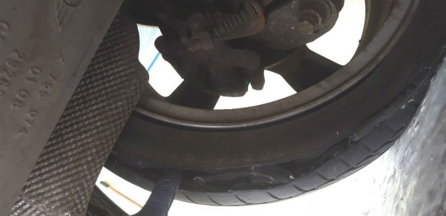 Someone poking a finger into a giant split in a tyre.