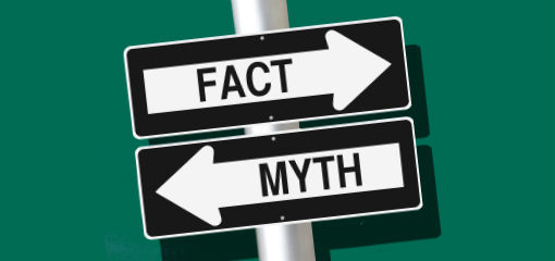 signs pointing in opposite directions. One says 'fact', the other says 'myth'