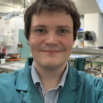 Image of a male wearing a green lab coat