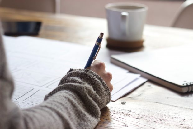 Person sat at a desk writing