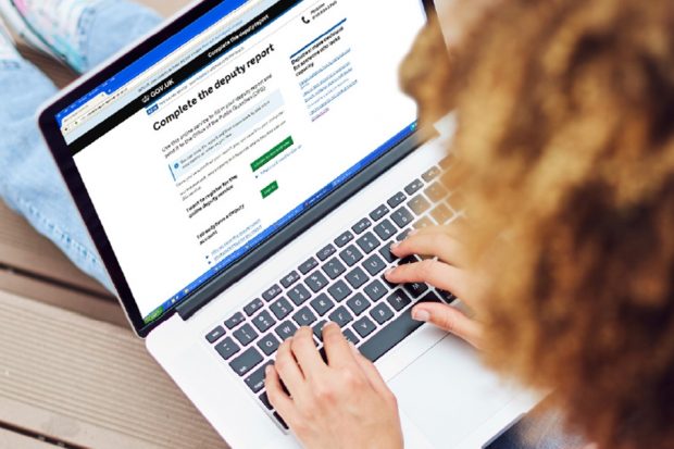 Person sitting at a laptop looking at the deputy report onscreen