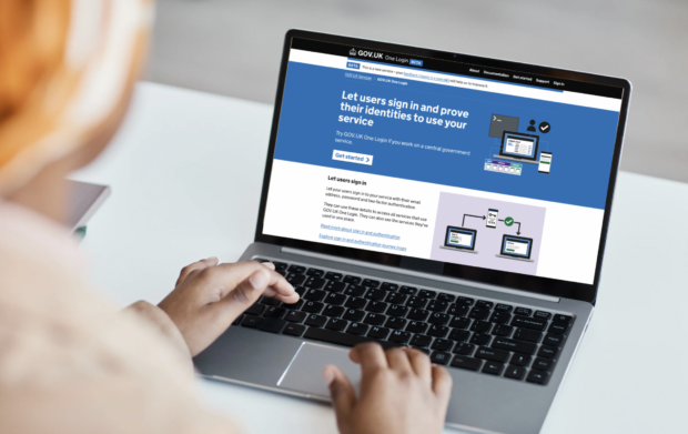A person using a laptop with the screen showing the One Login homepage