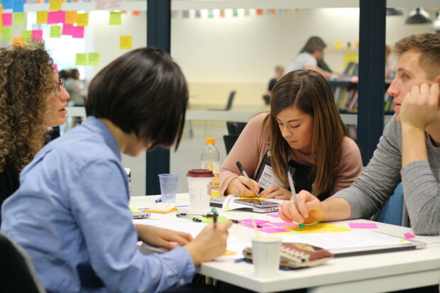 a picture of content designers writing down ideas at a content crit