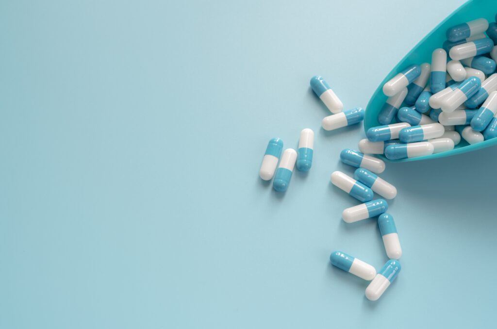 Blue and white antibiotics scattered on a blue surface