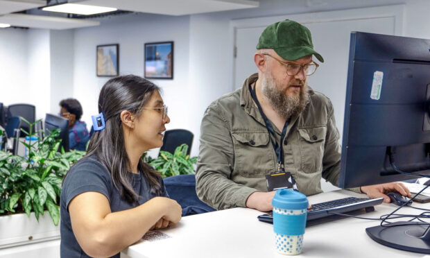 Two colleagues looking at a computer screen together