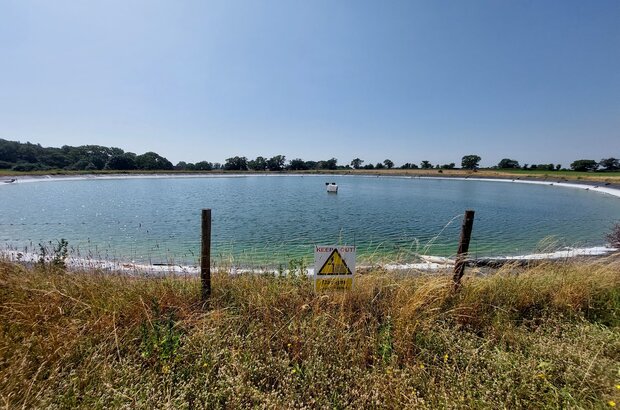 Waterbody fenced off under sunny skies
