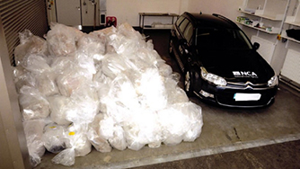 Stack of drug packages laid out next to NCA car