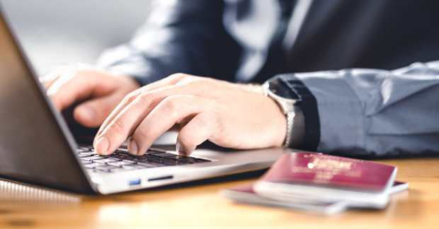 Man with passport and laptop. Travel document and identification.