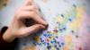 A hand pinning dots on a map