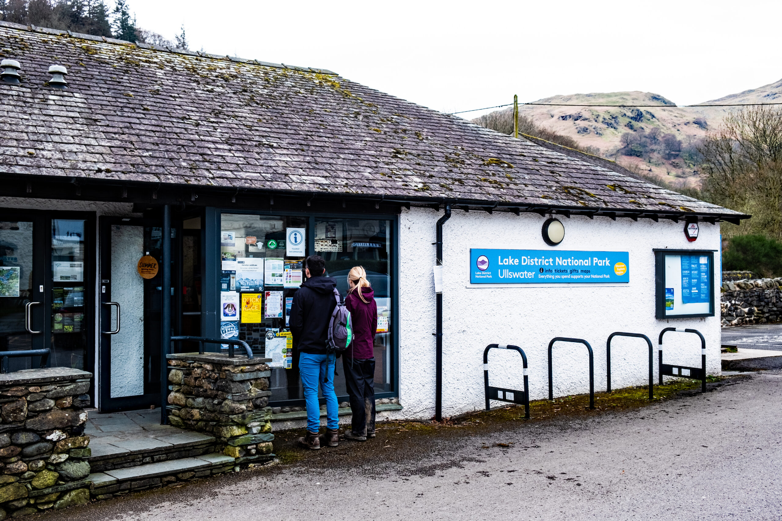 A couple stood looking into the Ullswater visitor centre