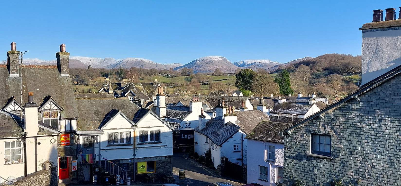 high view of white walled and grey slate roof houses in hawkshead village