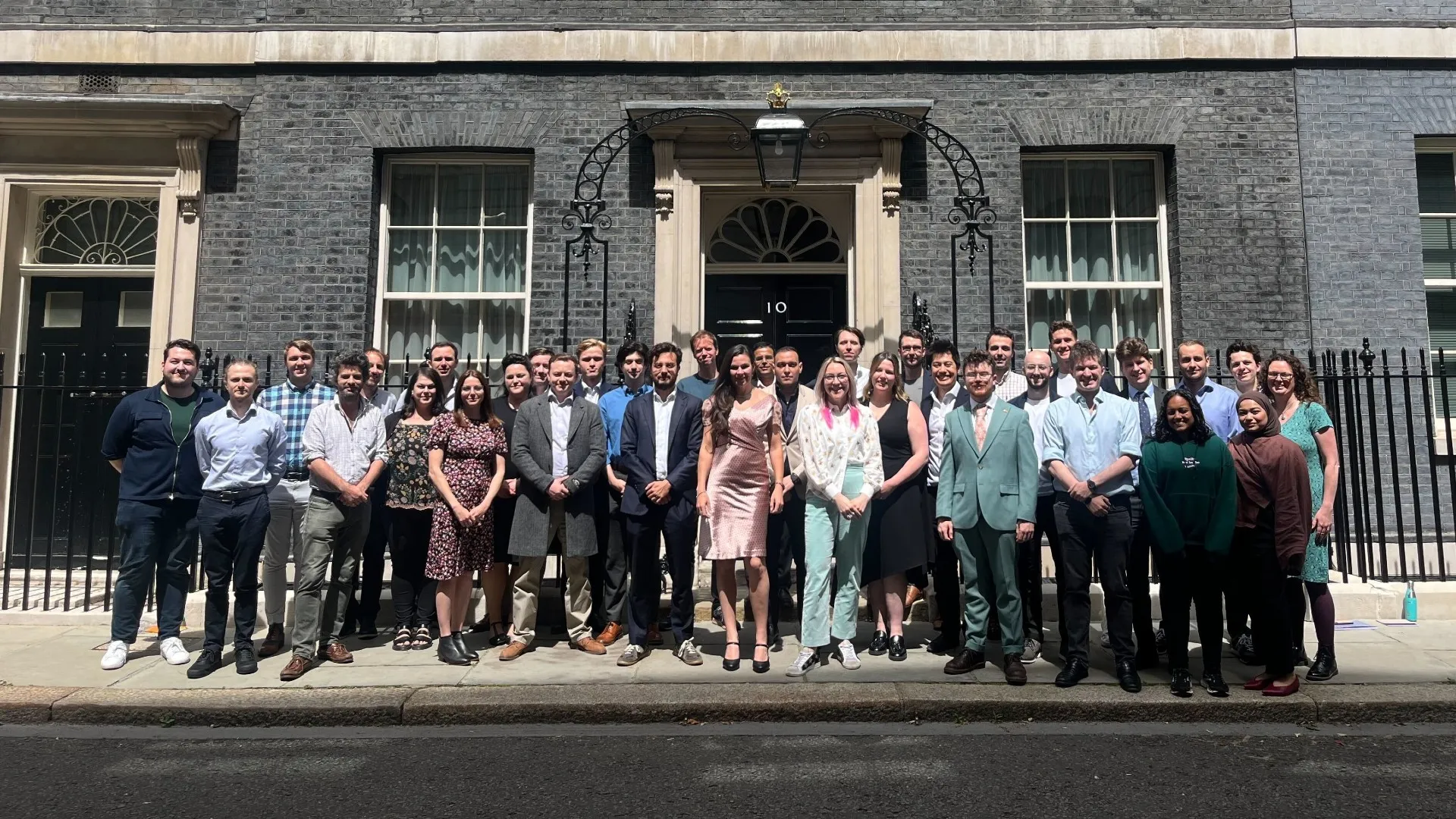 A group photo of the team standing outside 10 Downing Street