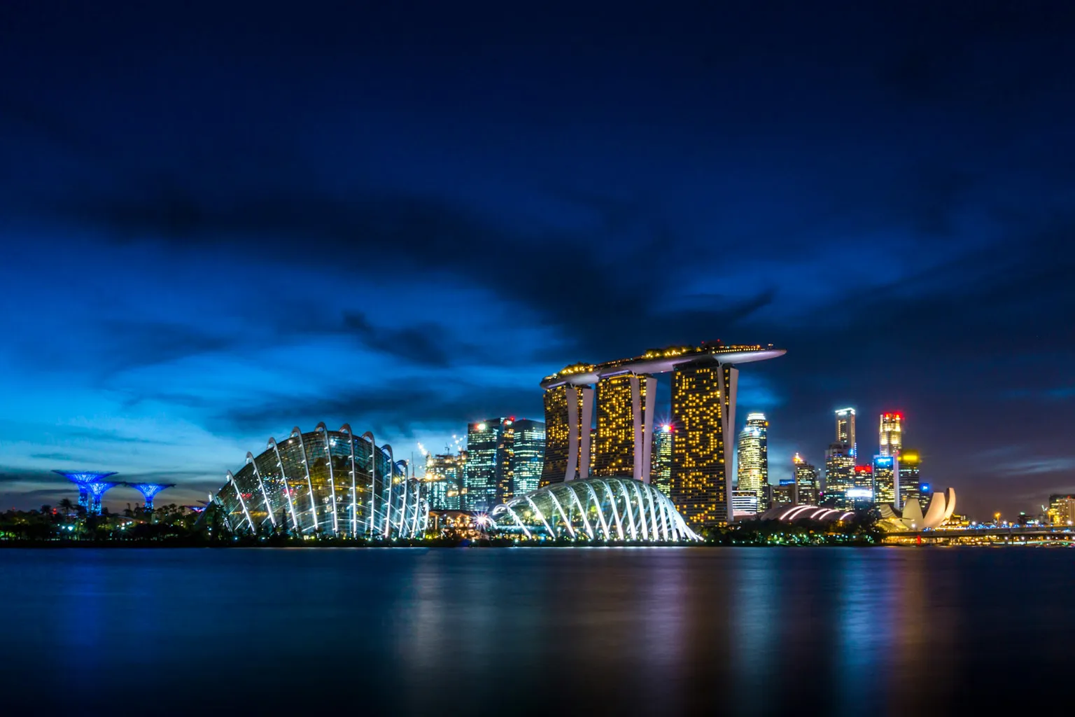 The Singapore skyline at dusk, looking across San Marina bay at the lit-up buildings