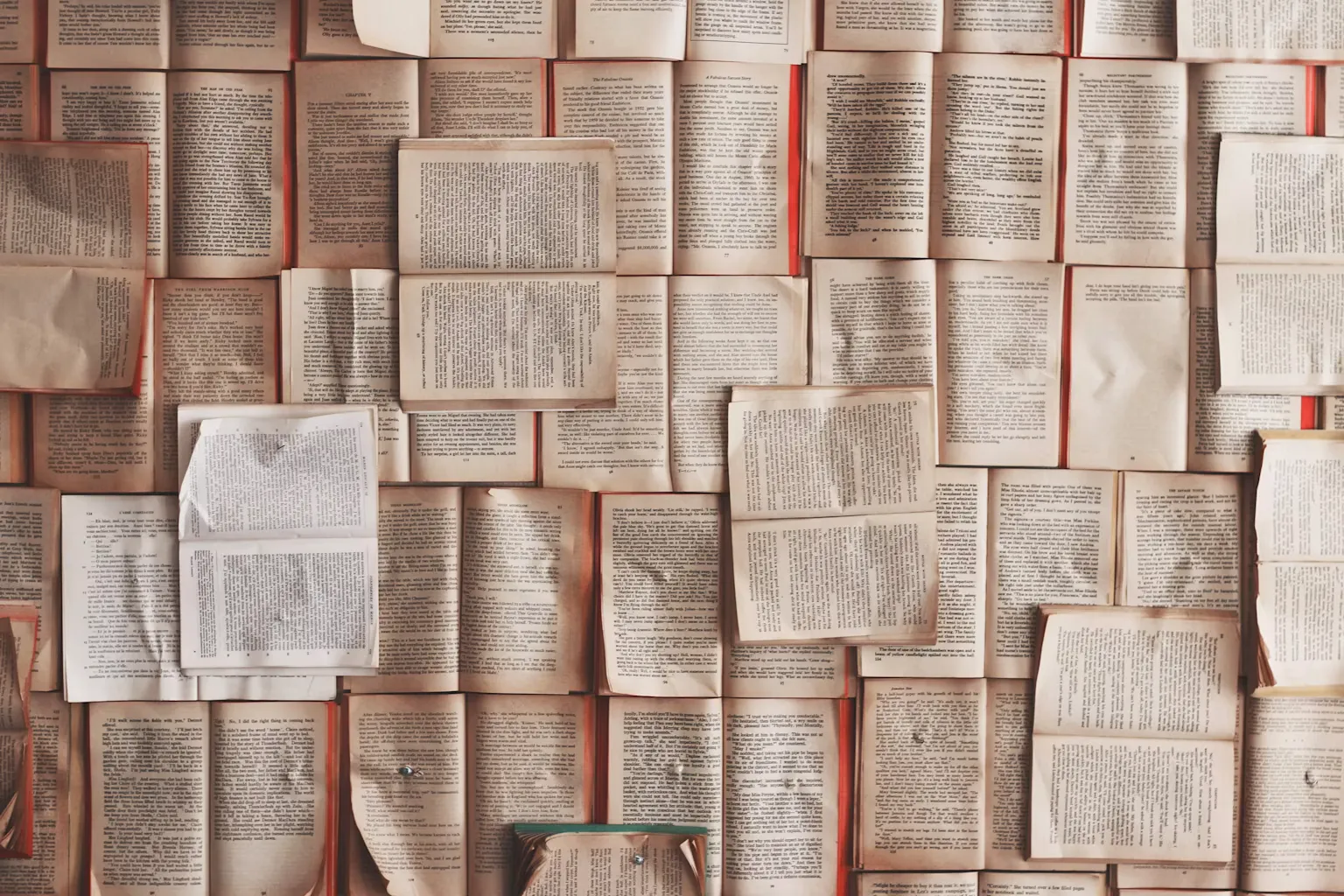A mosaic of open books laid out next to and on top of each other