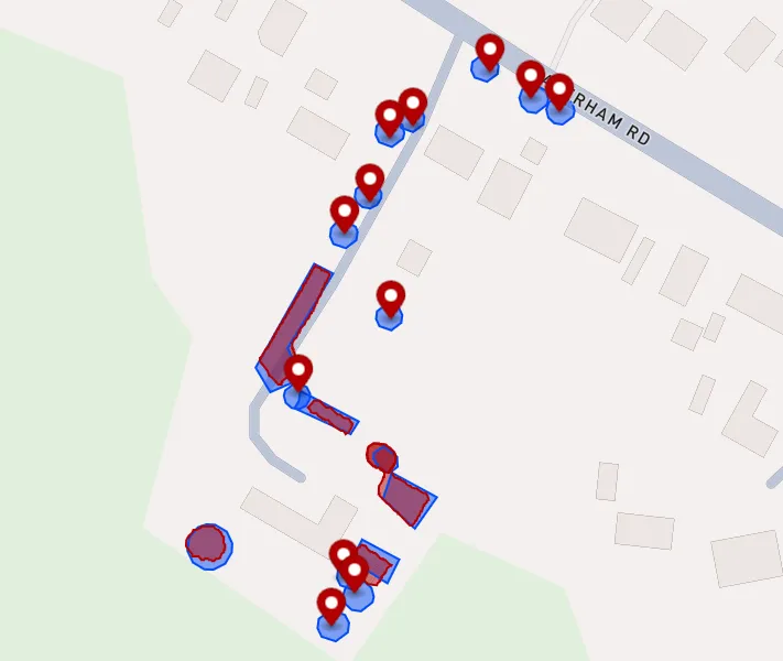 a street map with blue circles and areas and red areas and markers roughly in the same place