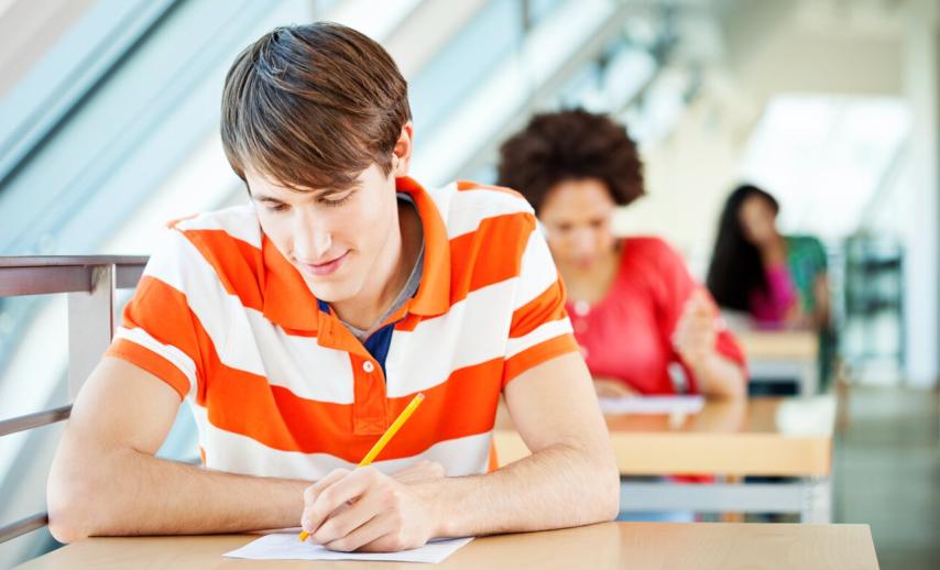 A student writes something on paper