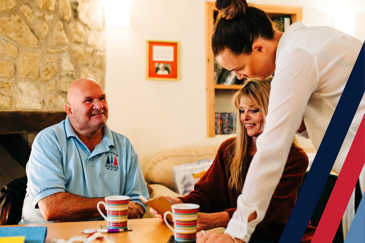 Two women and a man enjoying a cup of tea around a table at Woody's Lodge, a VALOUR-recognised veteran support centre in South Wales.