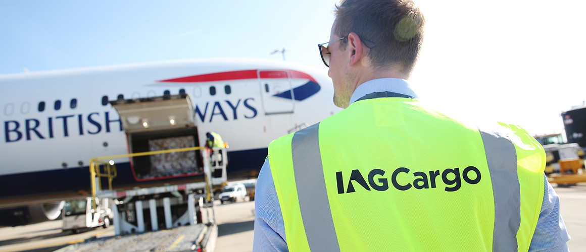 A photo of an airport worker in front of a loading plane