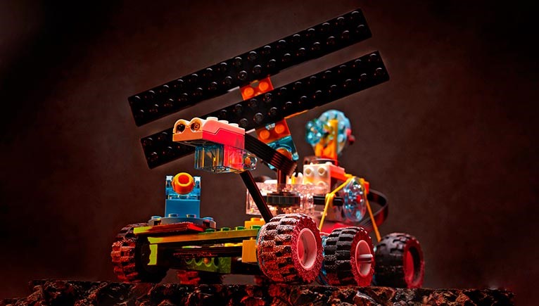 A futuristic LEGO vehicle with six wheels and a large propeller