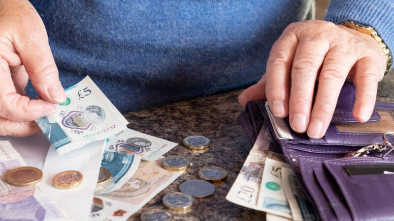 A man counting money from a wallet symbolising financial support for veterans.