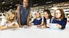 Athrawes a disgyblion mewn llyfrgell