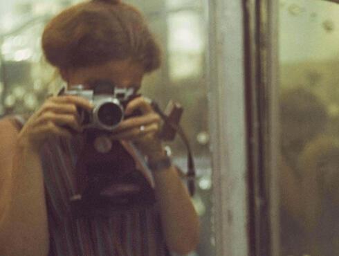 Photograph of Denise Scott Brown taking a photograph of herself in a mirror