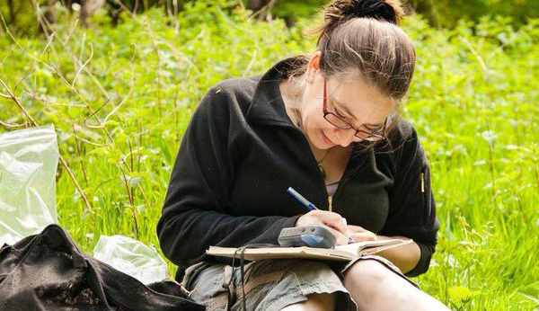 Erica making notes while working in the field