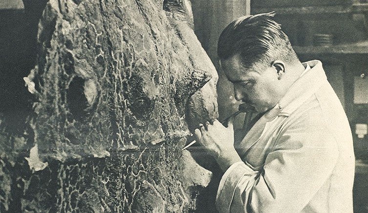Louis Parsons using a hammer and chisel on a fossil of Scolosaurus