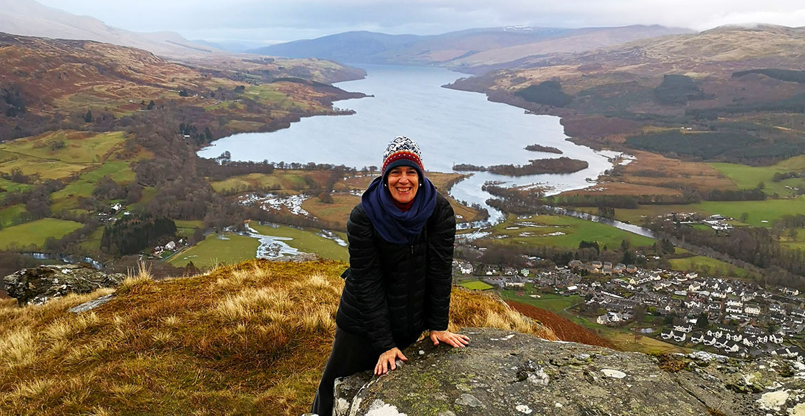Sandy standing on top of a large hill in the countryside