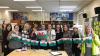 Group of people holding Welsh flags in school classroom 