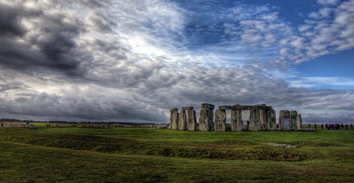 Stonehege sits in the middle distance, with a dramatic cloudy sky above. 