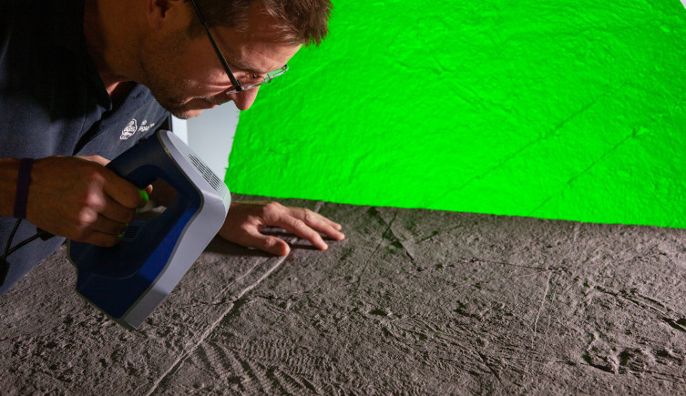 Dr Phil WIlby with a laser scanner looks at the fossil imprint